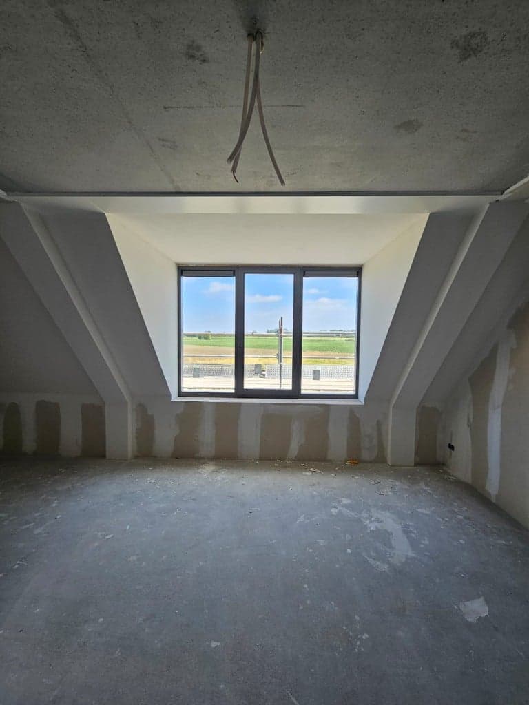 Dakkapel met gipsplaten en voegwerk rond het raam